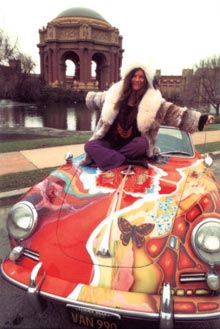 Janis Joplin sitting on a car